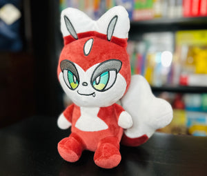 Three-quarter view of the Folkachi plush from Histrobea Chronicles, displaying its red and white design, green eyes, and fox-like features. A collectible plush toy connected to the HoopsandHipHop YouTube channel.