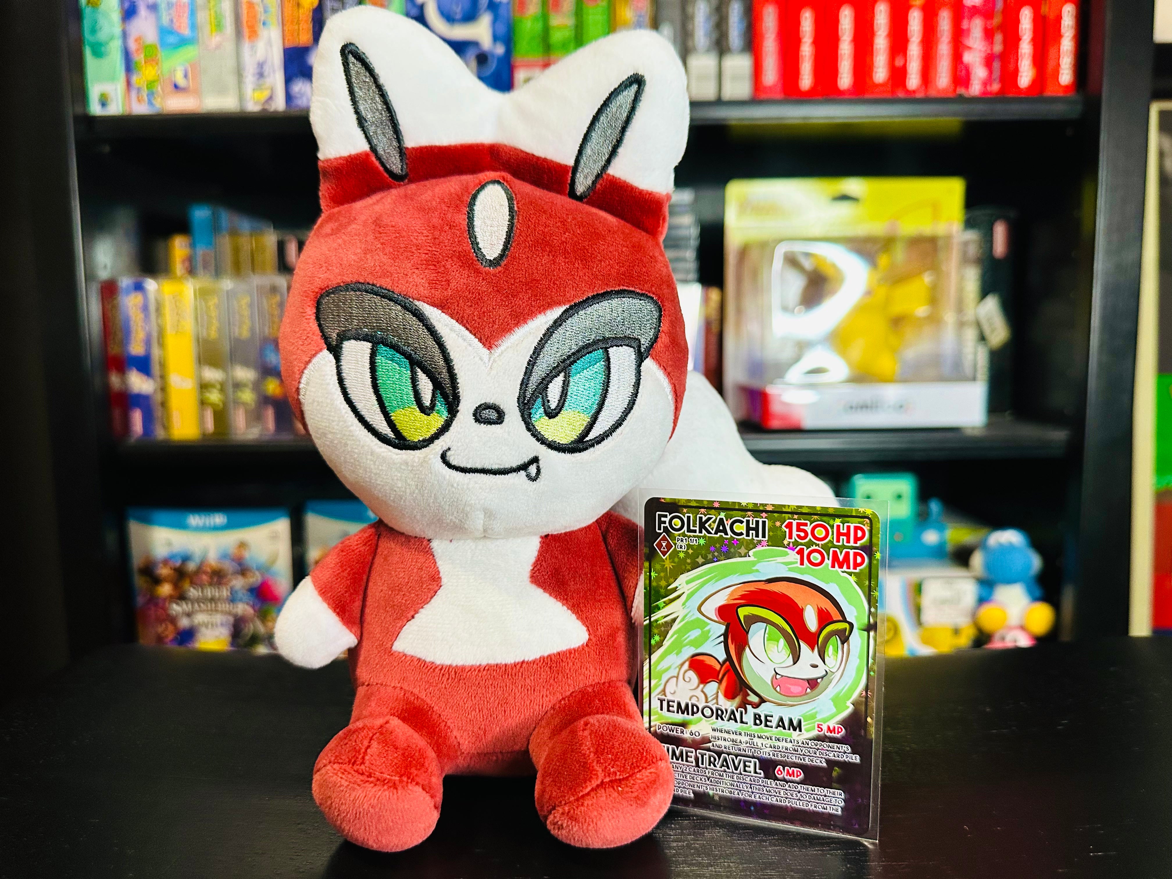 olkachi plush from Histrobea Chronicles, a red and white character with large green eyes, posed next to its trading card featuring 150 HP and Temporal Beam attack. A collectible plush toy from the HoopsandHipHop YouTube brand.