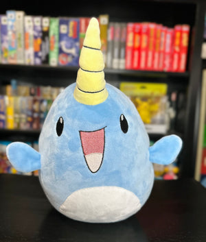 Front view of the Narwade plush from Histrobea Chronicles, featuring its wide smile, blue body, and iconic yellow horn. Part of the HoopsandHipHop YouTube channel's collectible plush series.