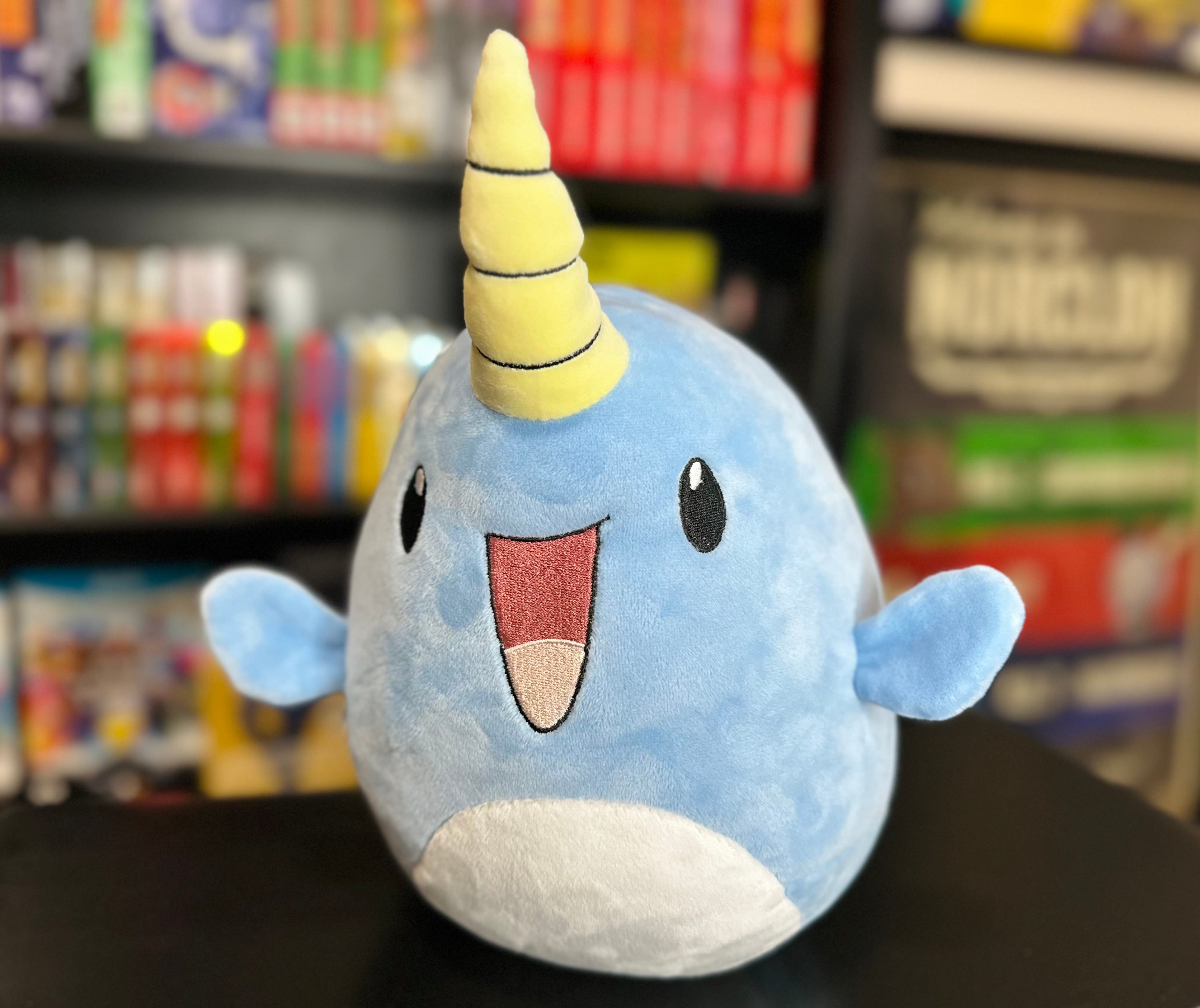 Three-quarter view of Narwade plush from Histrobea Chronicles, showcasing its playful design with blue fur, a cheerful smile, and a yellow spiral horn. A must-have for plush collectors.