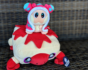 Snugooi and Torfrug plushes from Lockstin & Gnoggin's Lockemon series, featuring Snugooi sitting atop Torfrug. Torfrug is a tofu frog with a red maple leaf on its back, while Snugooi is a sea slug character with pink and blue accents. Ideal for fans of the Lockemon universe and collectible plush toys.